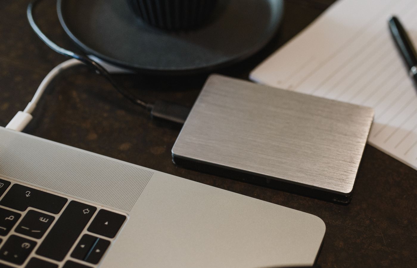 Portable backup drive connected beside a laptop